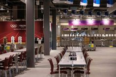 the inside of an olympic venue with tables and chairs set up for people to eat