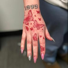 a woman's hand with red butterflies on it and the word happy written in silver