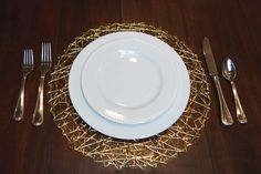 a white plate sitting on top of a wooden table next to silverware and utensils