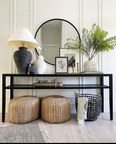 a black table with two stools and a mirror on the wall behind it,