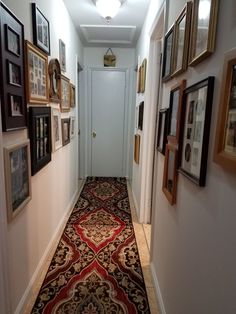 a long hallway with pictures on the wall and carpeted floor in front of it