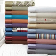 a stack of folded sheets sitting on top of a bed