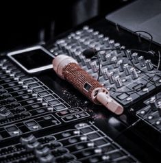 an electronic device sitting on top of a table next to sound mixers and keyboards