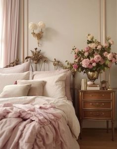 there is a bed with pink sheets and flowers on the headboard in this bedroom