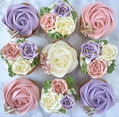 cupcakes decorated with flowers and leaves are arranged in a circle on a marble surface