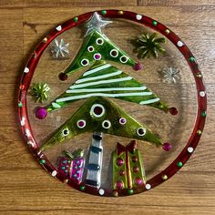 a glass plate with a christmas tree on it and other decorations in the shape of trees