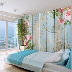 a bedroom decorated in pastel blue and pink with flowers on the wall behind it