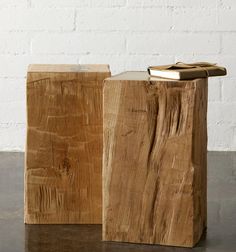 two pieces of wood sitting next to each other on top of a wooden table with white brick wall in the background