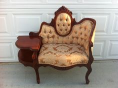 an old fashioned chair and table in front of a garage door