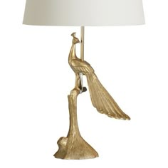 a gold bird lamp with a white shade