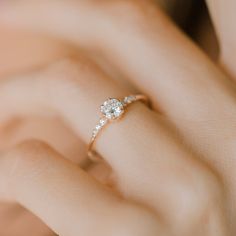 a woman's hand with a diamond ring on it