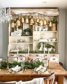 a dining room table and chairs with christmas decorations on the top shelf, in front of an old china cabinet