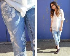 a woman in white shirt and jeans standing next to blue wall