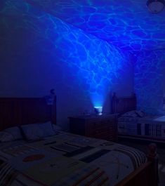 two beds in a room with blue lighting