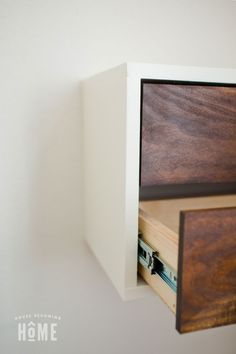 a close up of a drawer in a wall with white walls and wood trimmings