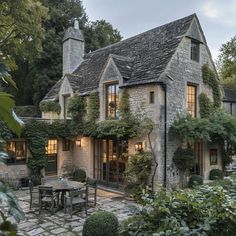 an old stone house is surrounded by greenery