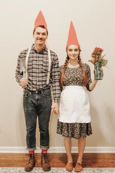 a man and woman standing next to each other wearing gnome's hats on their heads