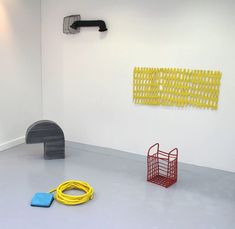 a yellow hose is laying on the floor next to a blue and yellow object in an empty room