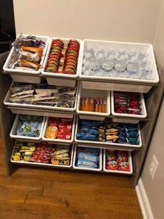 an assortment of snacks and drinks are stacked on top of each other in bins