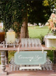 a wooden table topped with lots of glasses