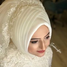 a woman wearing a white hijab with lace on it's head and her hair pulled back