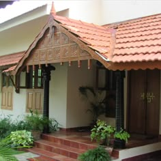 a house that has some plants on the front porch and steps leading up to it