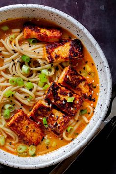 a white bowl filled with noodles and tofu