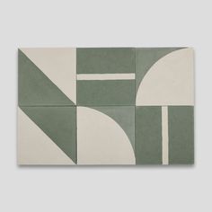 a green and white tile wall with geometric shapes in the center, on a gray background