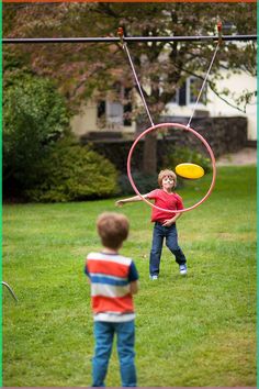 two young boys playing with a hoop and frisbee