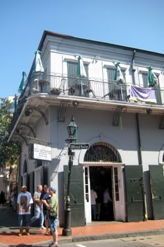 people are walking in front of an old building with balconies on the balcony