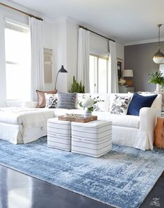 a living room filled with white furniture and blue carpeted flooring on top of a rug