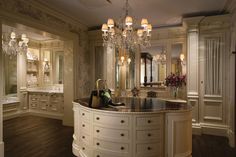 a fancy bathroom with chandelier and marble counter tops, along with an oval sink