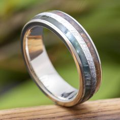 a wedding ring with an antler wood inlay and gold plated inside, on top of a wooden table