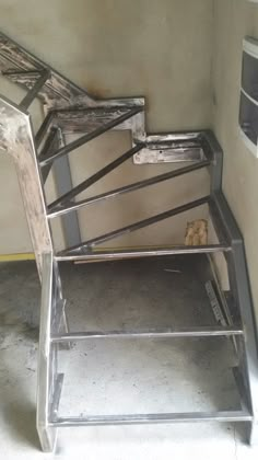 a set of metal steps in an unfinished room