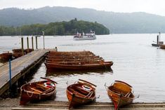 several small wooden boats docked at a pier