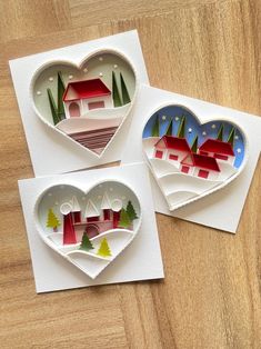 three pieces of paper are arranged in the shape of heart - shaped houses and trees