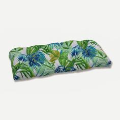 a green and blue tropical print neck pillow on a white background, with palm leaves