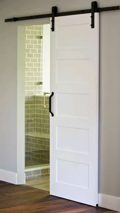 an open white door in a room with wood floors