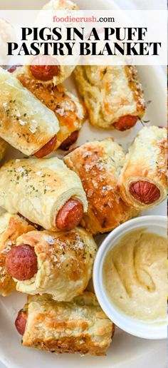 pigs in a blanket pastry with mustard and ranch dressing on the side, next to a plate of hotdogs