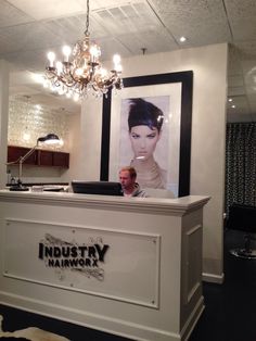 the inside of a hair salon with chandelier hanging from the ceiling and pictures on the wall