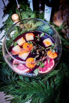 a glass bowl filled with fruit on top of a table