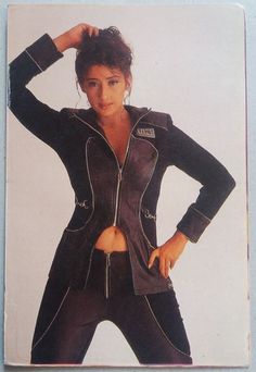 a woman with her hands on her hips wearing a black leather jacket and matching pants