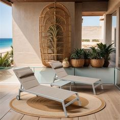 two lounge chairs sitting on top of a wooden floor next to a glass table and potted plants