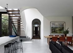 a living room filled with furniture next to a staircase