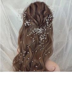 the back of a woman's head with long hair and flowers in her hair