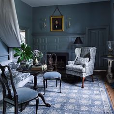 a living room filled with furniture and a painting hanging on the wall above a fire place