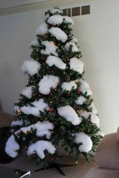 a snow covered christmas tree in a living room