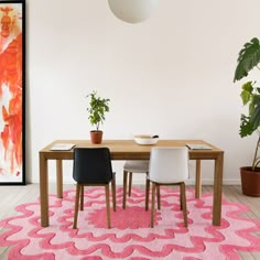 a dining room with pink rug and white chairs