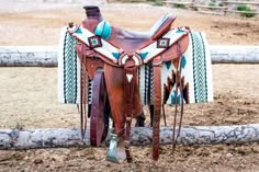 a horse saddle sitting on top of a dirt field