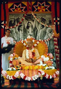 a man sitting on top of a bed surrounded by flowers